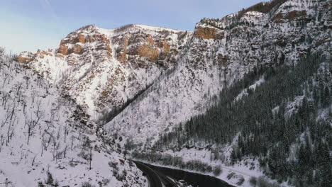 colorado river streaming through the glennwood caynon while peaks are illuminated by setting sun