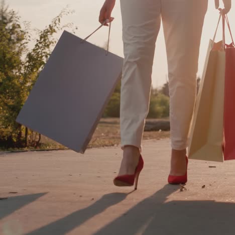 stylish woman walks down the street with packages of multi-colored shopping packages