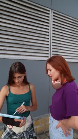 two teenage girls discussing digital art