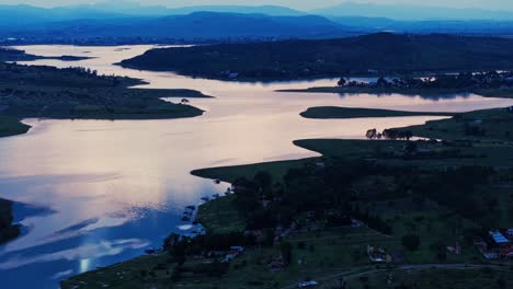 drone trucking pan tilts up slowly establishing unique blue hour landscape of winding waterway in puebla mexico