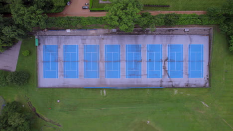 Vista-Aérea-De-Las-Canchas-De-Tenis-Con-Un-Descenso