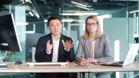 a team of business employees at an online meeting look at camera and communicate. webcam view. conference remote interview. two office workers talking video call conversation