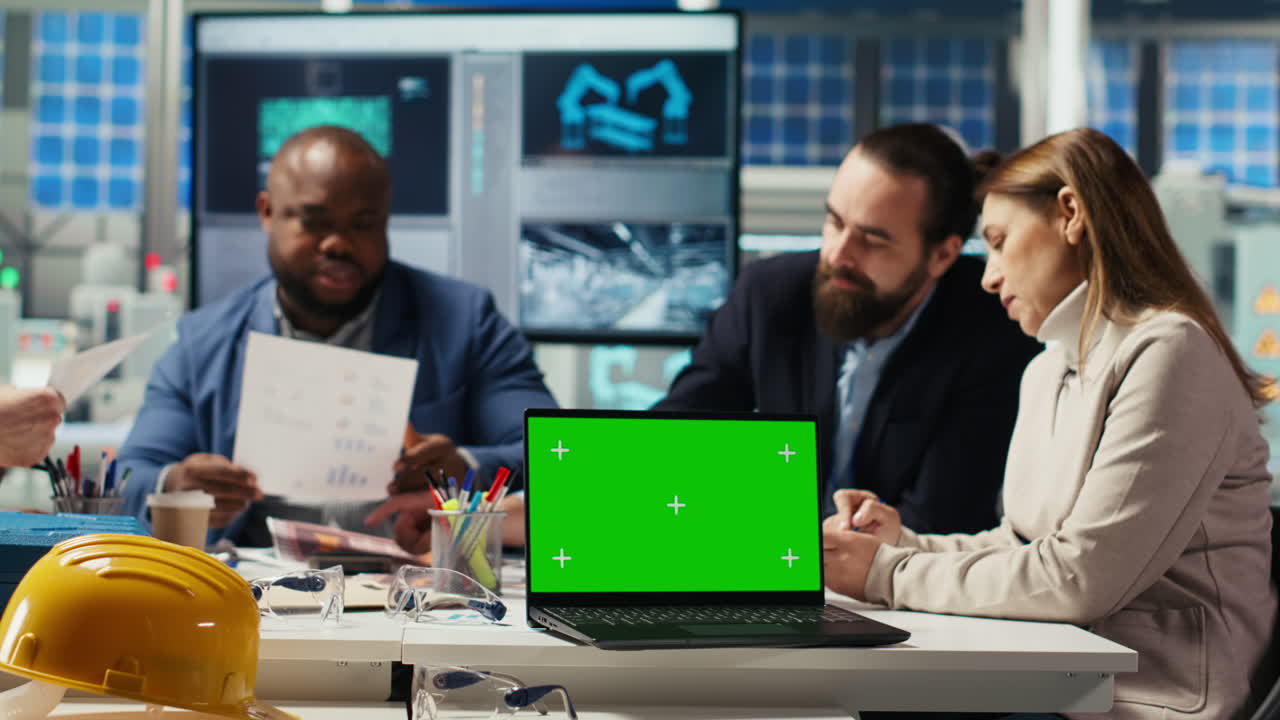 Factory Engineers Refining Production Layouts Using Chroma Key Laptop
