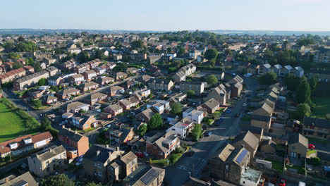 Drone-captured-aerial-footage-reveals-Dewsbury-Moore-Council-estate,-UK,-with-red-brick-housing-and-Yorkshire's-industrial-landscape-on-a-sunny-summer-morning