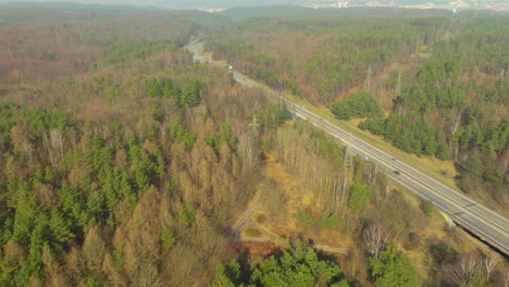 aerial view capturing a stretch of highway meandering through a forested landscape