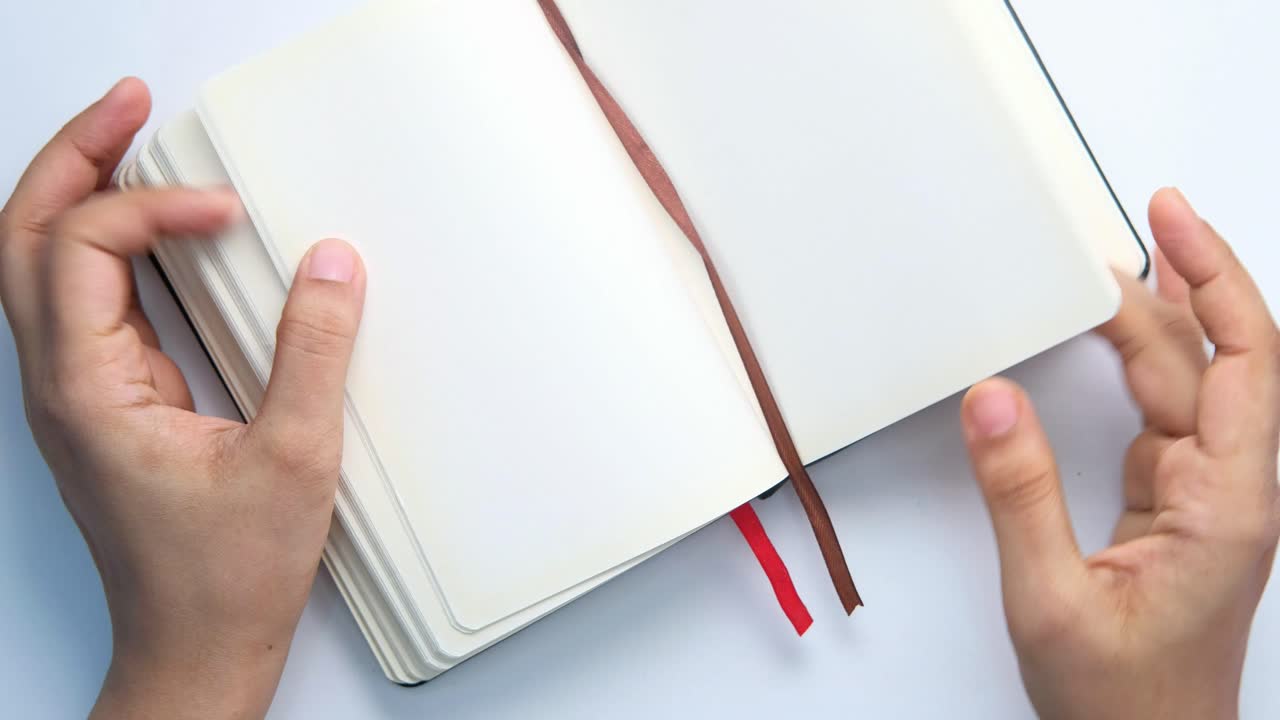 Hands holding an open notebook