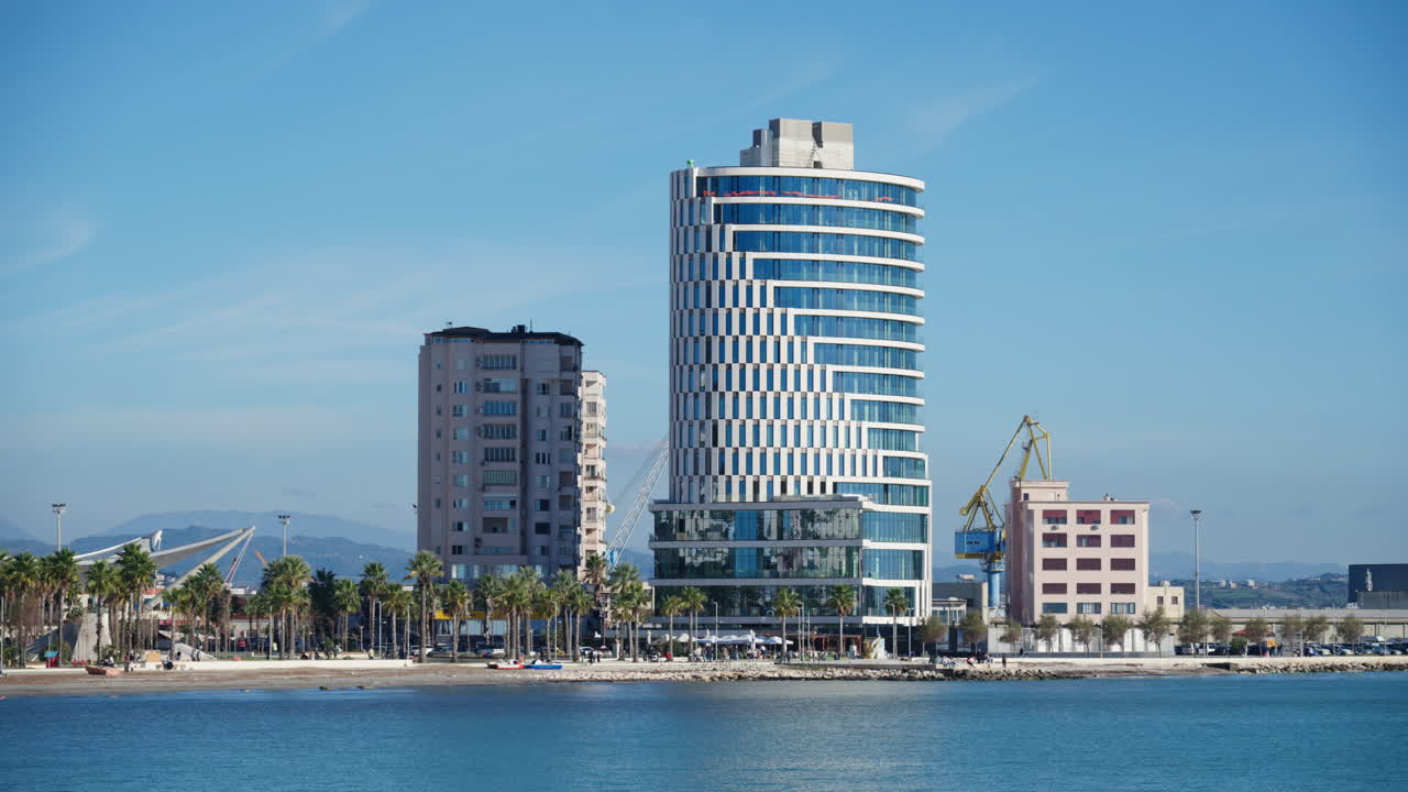Horizonte costeiro da cidade de Durres ao longo do Mar Adriático, com edifícios modernos, palmeiras e uma praia
