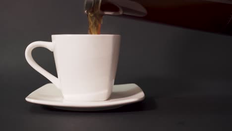 pouring french press coffee into white cup - closeup