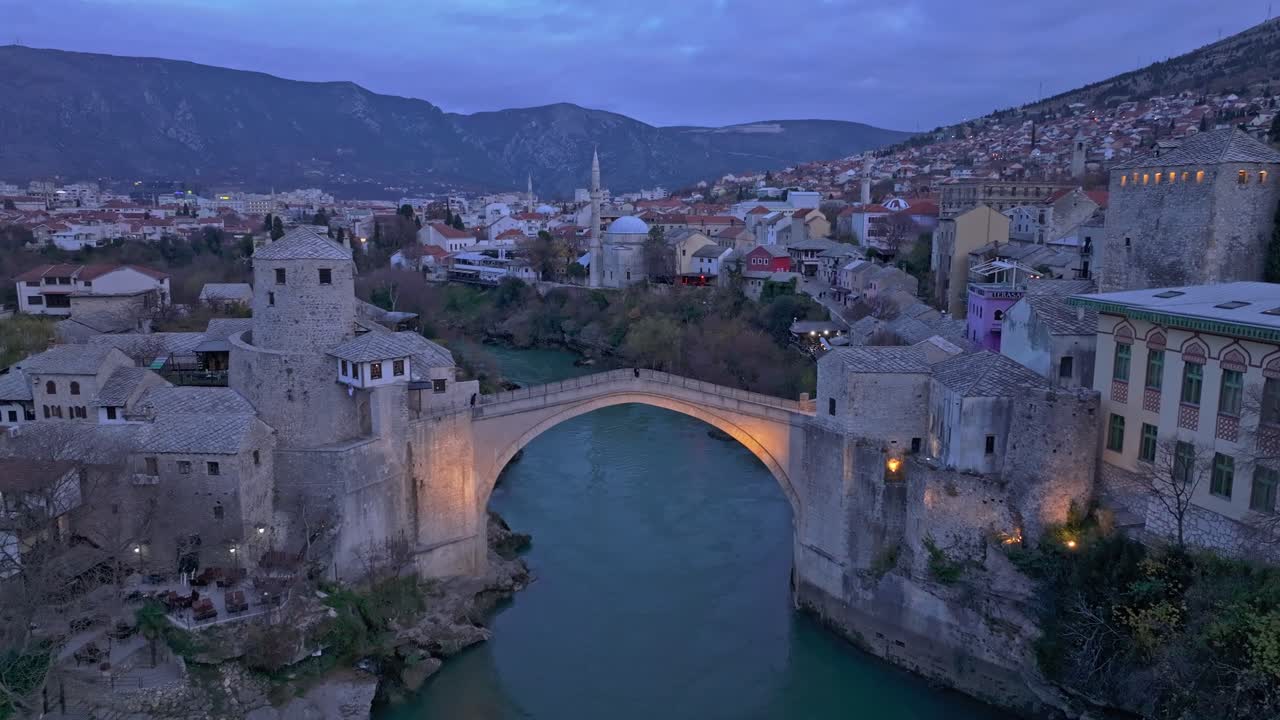 Tomada de drone da icônica ponte Stari Most sob as cores suaves do pôr do sol