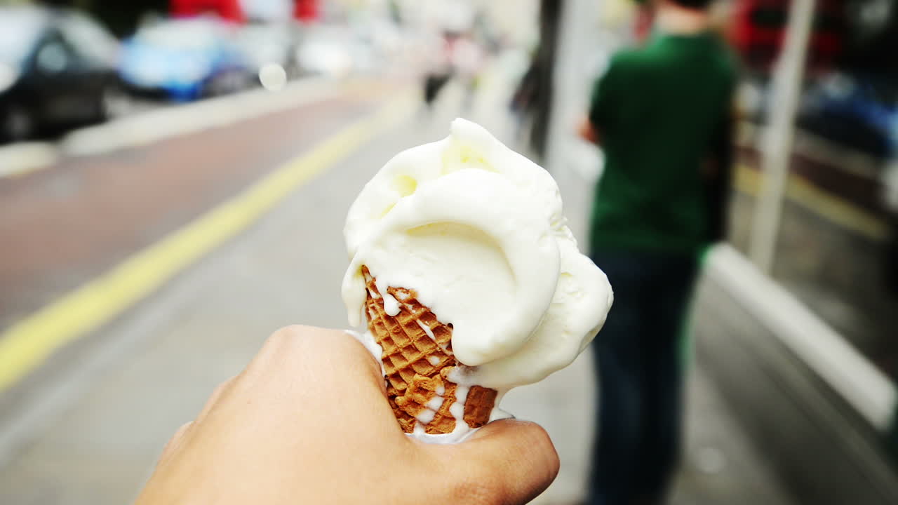 아이스크림을 들고 도시를 걸어다니는 사람