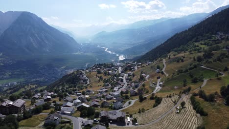 small mountain village guttet-feschel in the valley of valais in the south of switzerland, mystic dust over the famous rhone river in the background