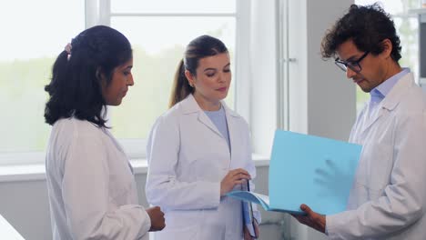 International-Group-of-Scientists-in-Laboratory.science-research,-work-and-people-concept-international-group-of-happy-scientists-with-clipboards-discussing-report-in-laboratory