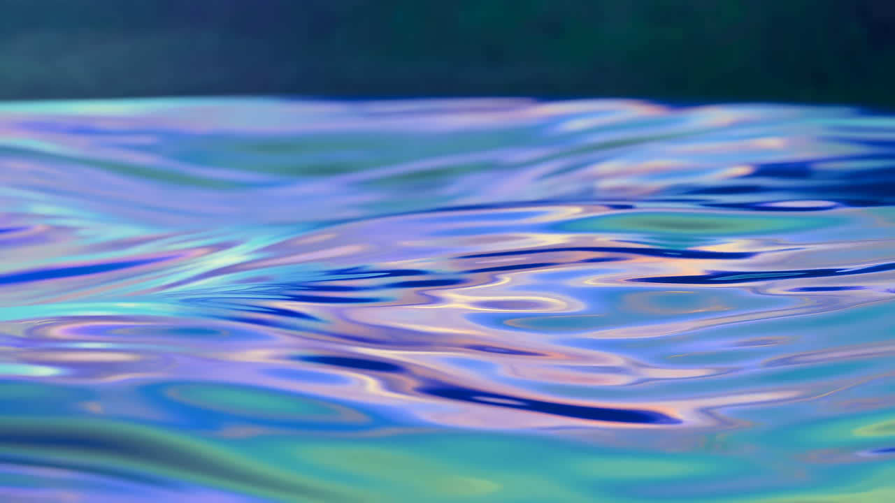Primo piano astratto di una superficie liquida iridescente con onde increspate.