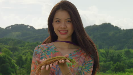 portrait of young vietnamese woman holding rice crop in vietnamese plantation