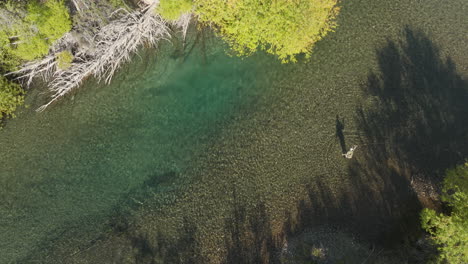 Increíble-Vista-Aérea-De-Arriba-Hacia-Abajo-De-Un-Hombre-Pescando-En-Un-Río-Cerca-De-Arroyo-Verde,-Argentina