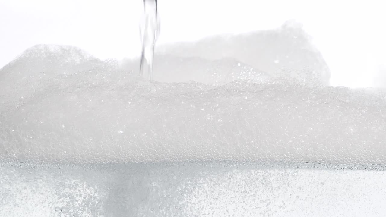 agua que cae en un tanque y la forma de la espuma en la superficie