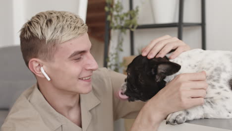 young man petting dog at home