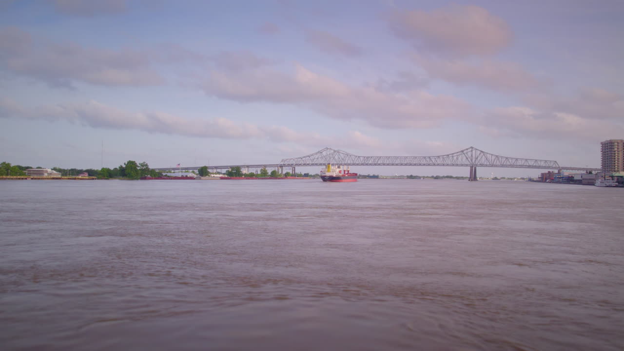 Follow behind a tanker ship moving towards bridge on the Mississippi River