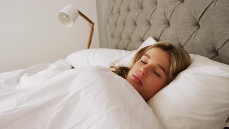 mujer joven durmiendo en su cama