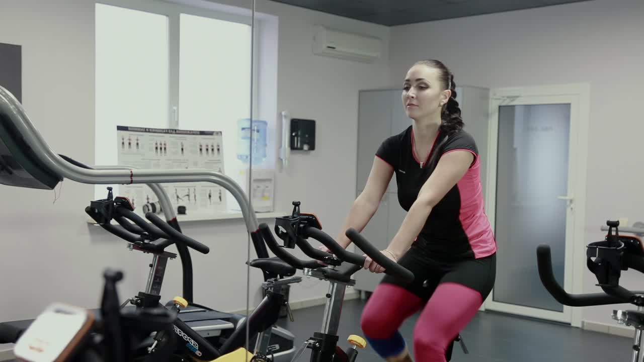 mujer trabajando en una bicicleta giratoria en un gimnasio