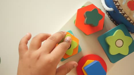 toddler playing with wooden shape sorter