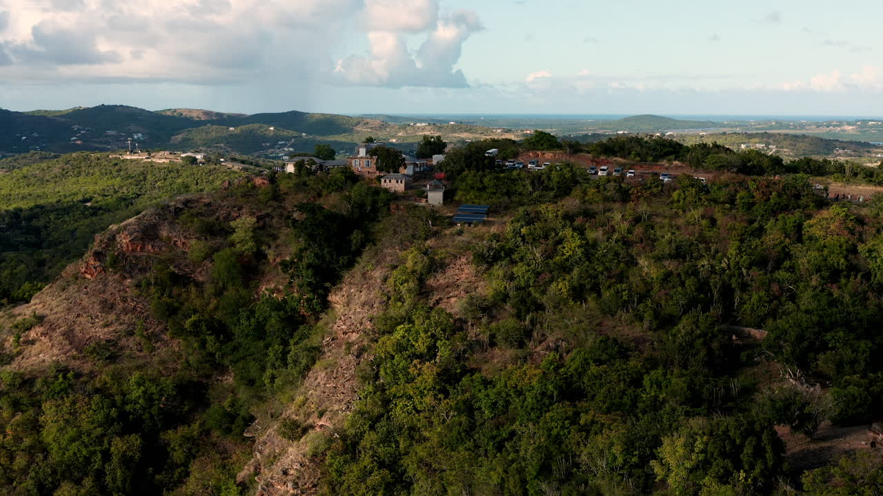 toma aérea soleada del puerto inglés en antigua, caribe con vistas de yates, veleros, puerto deportivo, bahía y acantilados