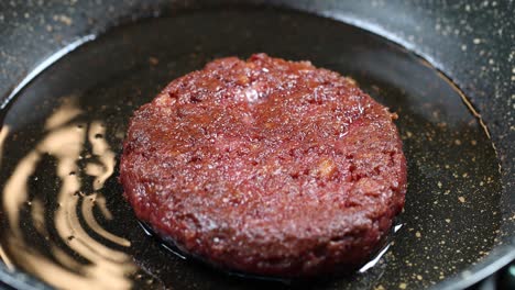 frying a plant-based burger in a pan