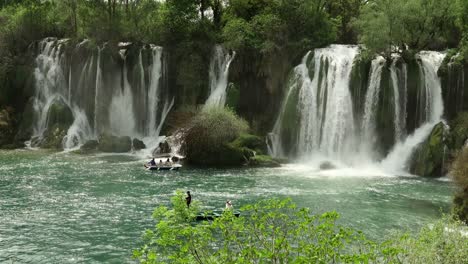 tourists in row boats get close to the spectacular kravica waterfalls in bosnia