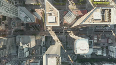 AERIAL:-Slow-uplifting-birds-eye-View-flight-over-Downtown-Los-Angeles-California-Grand-Avenue-in-beautiful-Sunrise-Light-with-view-of-skyscraper-rooftops-and-car-traffic-passing