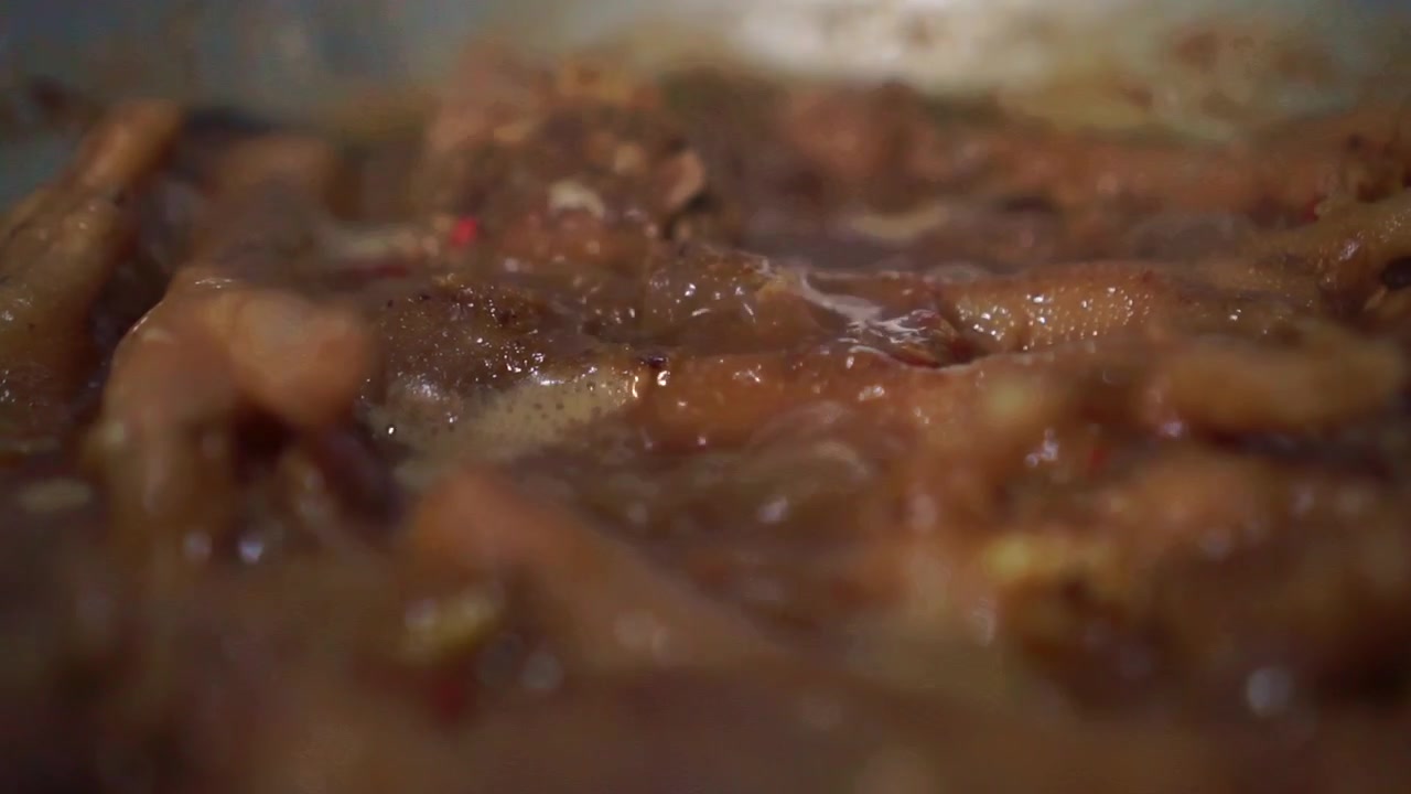 Deliziosi pezzi di pollo che sobbollono in una salsa saporita. Primo piano del processo di cottura con sugo che bolle e condimento saporito.