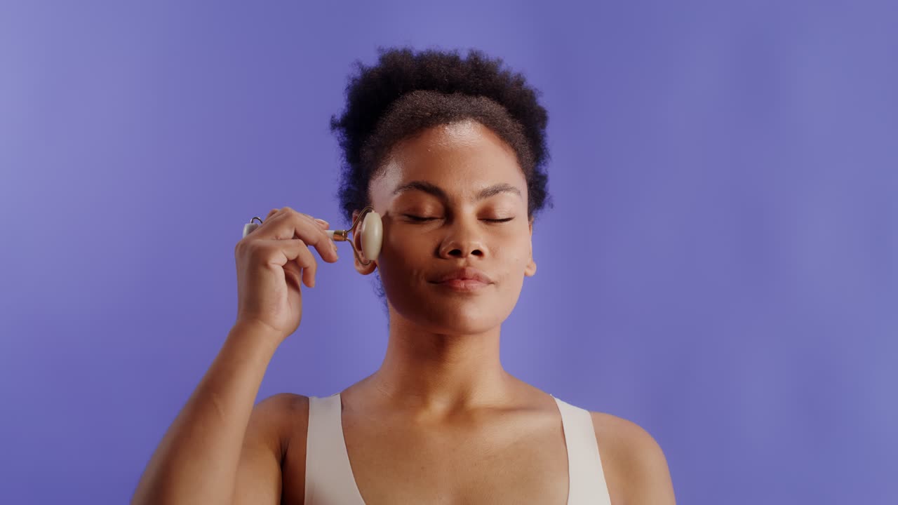 Woman using a face roller for skincare