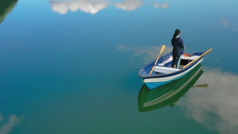 Una-Mujer-En-El-Barco-Pesca-Un-Pez-Girando-En-Noruega.