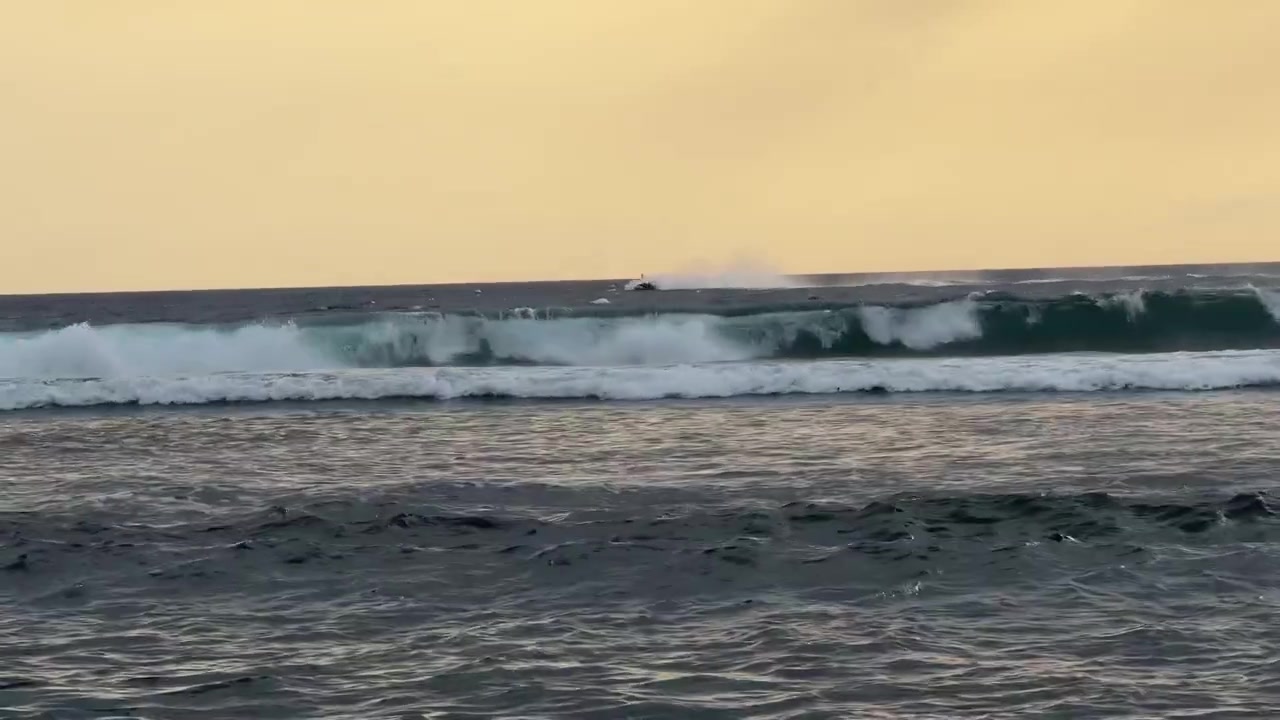 Jet Skis Riding Waves in the Ocean at Sunset