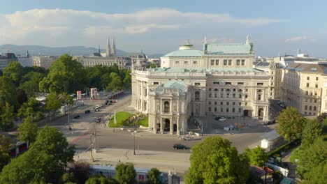 drone flies above park in vienna, reveals bus on city street in summer