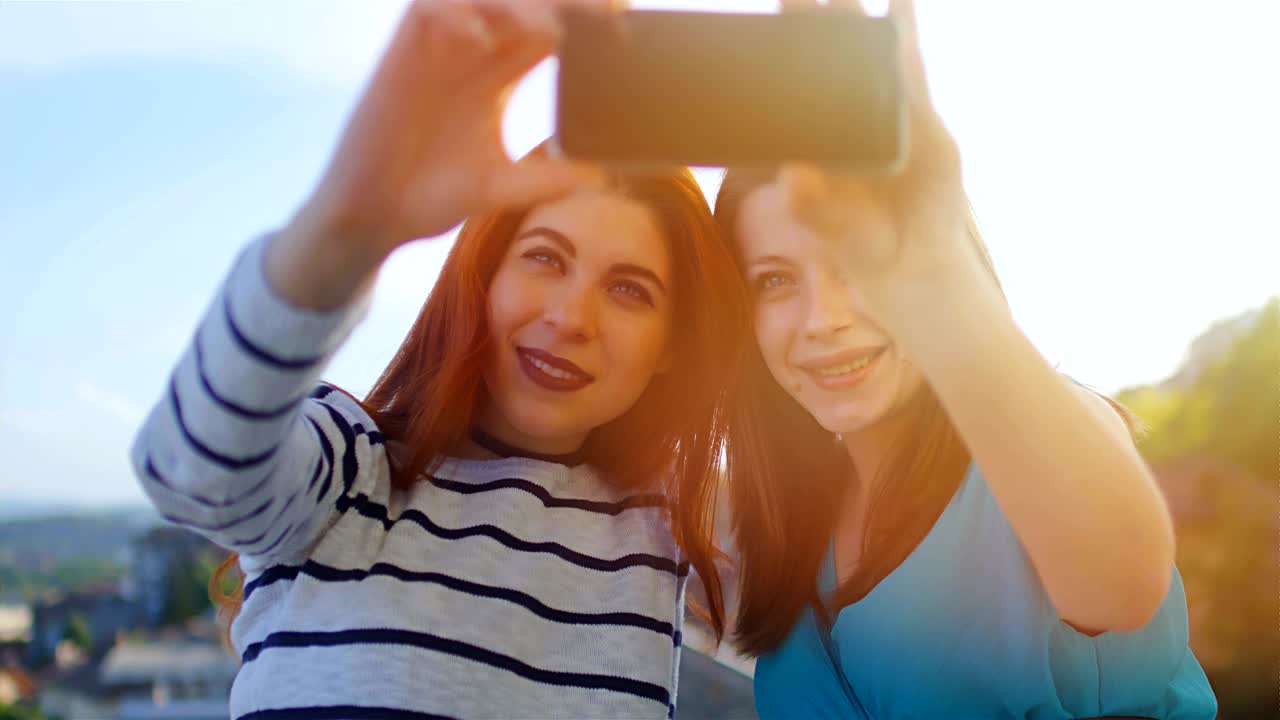 amigas caucásicas atractivas tomando selfies al atardecer, 4k