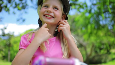 Mädchen-Setzt-Einen-Rosa-Fahrradhelm-Auf-Und-Schließt-Die-Verschlüsse