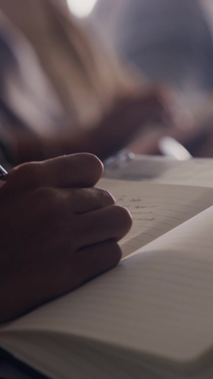 Business Professionals Taking Notes and Using Tablet in Meeting