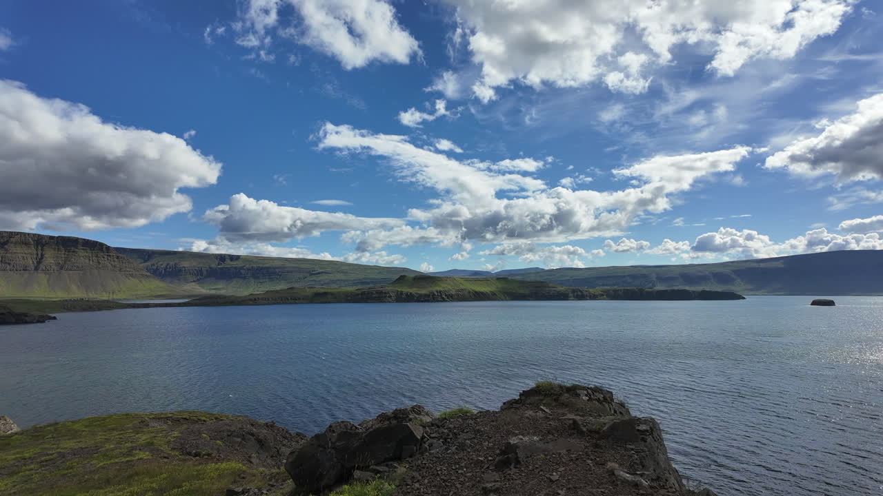 Stunning timelapse of Hvalfjörður's dramatic fjord landscapes in Iceland, showcasing majestic mountains reflected in calm waters under changing skies.