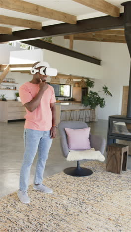 vertical video: using vr headset, man interacting with virtual environment in modern living room