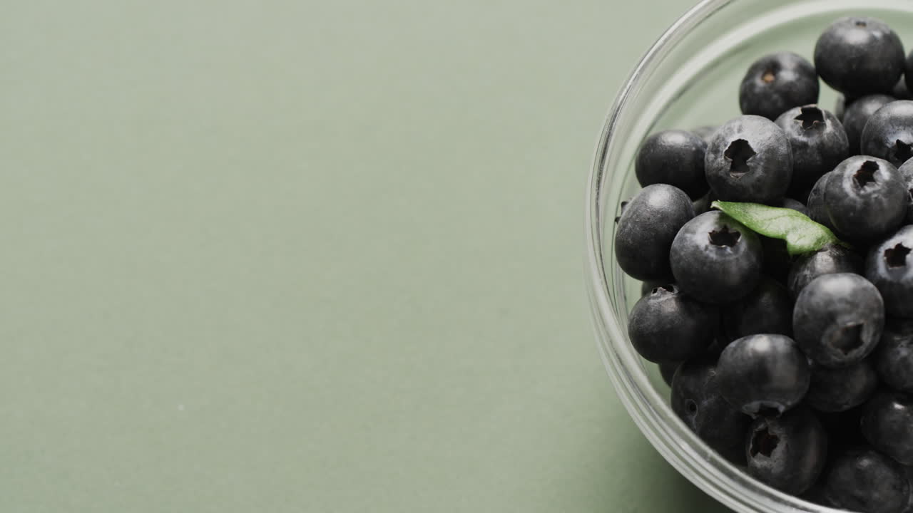 녹색 배경 에 복사 공간 을 가진 블루베리 가 있는 그 ⁇  의 클로즈업 의 마이크로 비디오