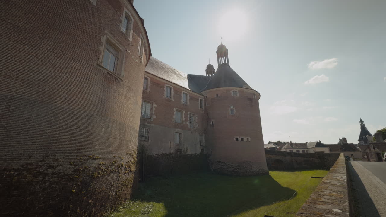 Pan shot of Castle of Saint-Fargeau beside vacant concrete pathway in France