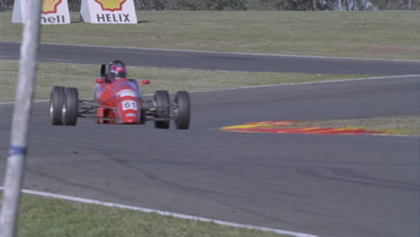 los autos en una pista de carreras giran a toda velocidad en una esquina y entran en otra
