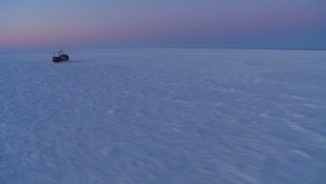 Hermosa-Antena-De-Un-Barco-Atrapado-En-El-Hielo-Congelado-De-La-Bahía-De-Hudson,-Churchill,-Manitoba,-Canadá