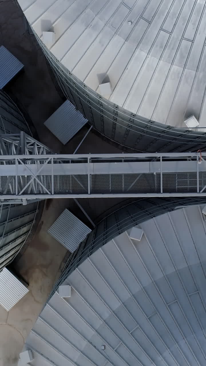 Huge elevator tanks of grain. Metal modern factory tanks. Aerial view. Vertical video