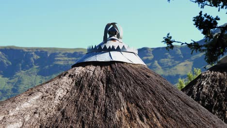 Ornate-custom-made-metal-rain-cap-tops-round-thatch-roof-in-Lesotho