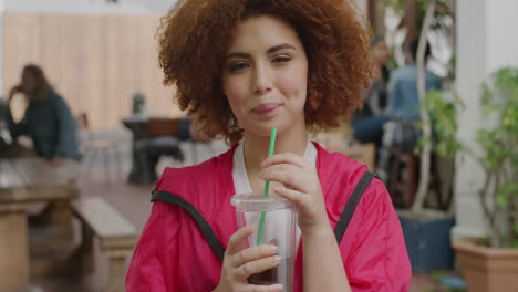 portrait of beautiful young woman drinking juice beverage smiling enjoying relaxed urban lifestyle in outdoors restuarant background satisfaction