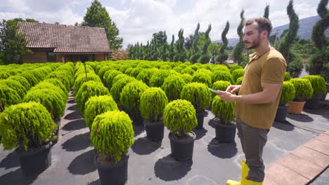 modern gardener working with his tablet in greenhouse.