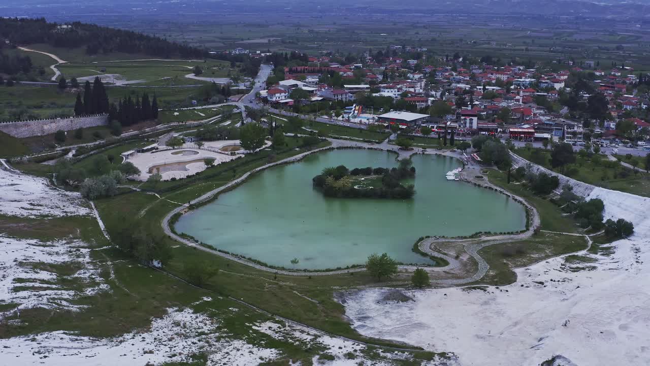 Drone circles the turquoise geothermal pool at Pamukkale natural attraction