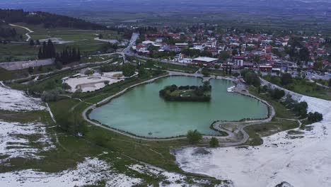 drone circles the turquoise geothermal pool at pamukkale natural attraction