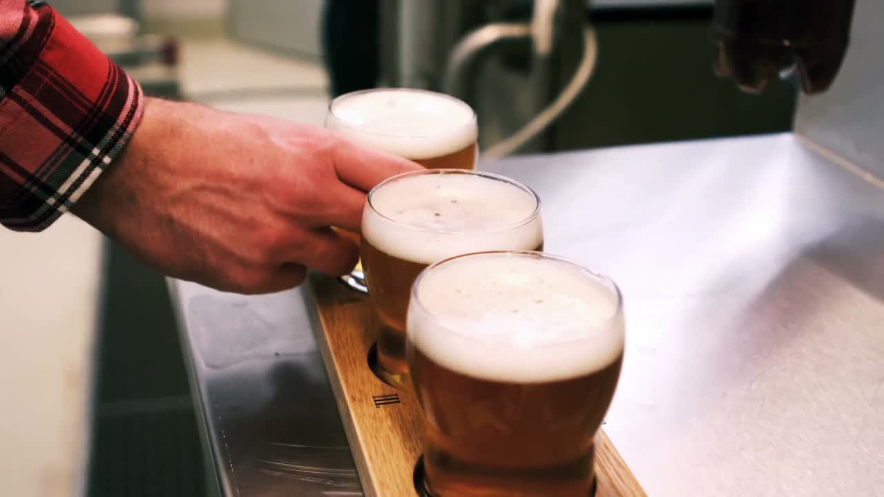 Brewer putting beer glass in beer sampler tray